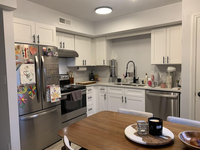 kitchen with stainless steel appliances, white cabinets, and sink