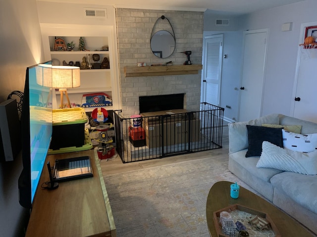 living room featuring a brick fireplace and light hardwood / wood-style floors