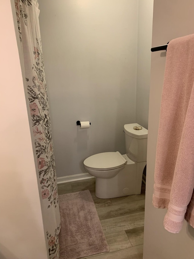 bathroom with toilet and wood-type flooring