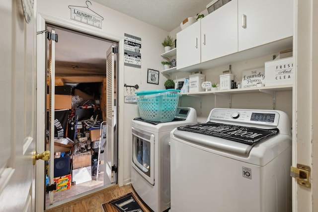 washroom with a textured ceiling, cabinets, independent washer and dryer, and hardwood / wood-style flooring