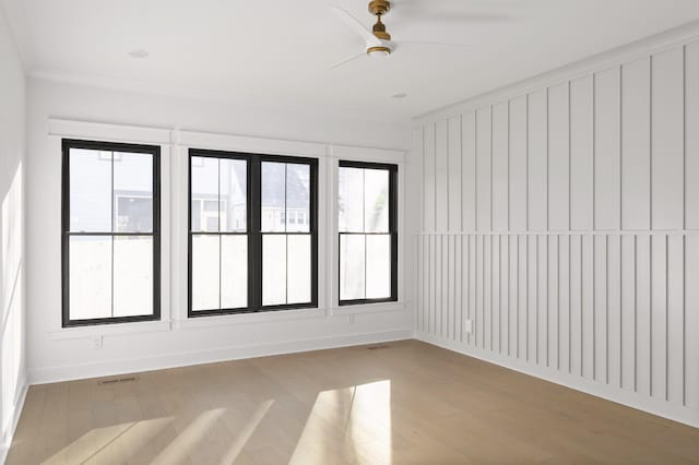 spare room with ceiling fan, crown molding, and light hardwood / wood-style floors