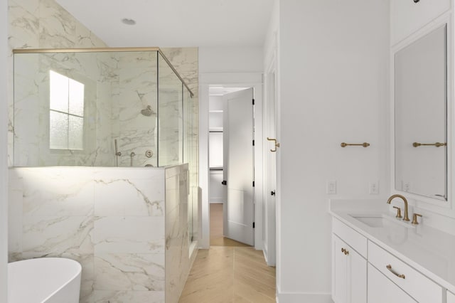 bathroom featuring hardwood / wood-style floors, plus walk in shower, and vanity