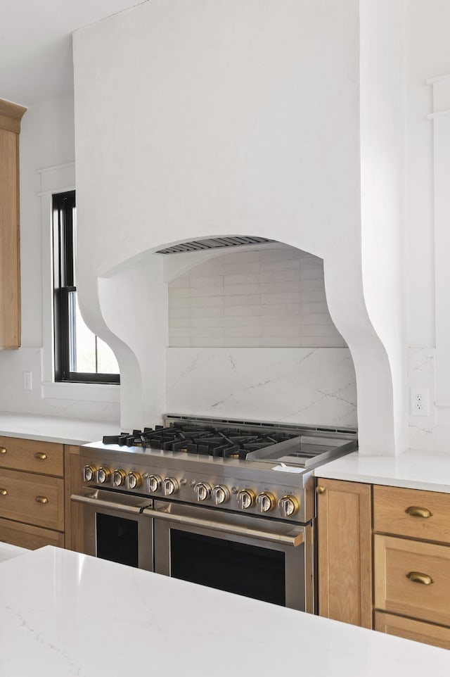 kitchen with double oven range and tasteful backsplash