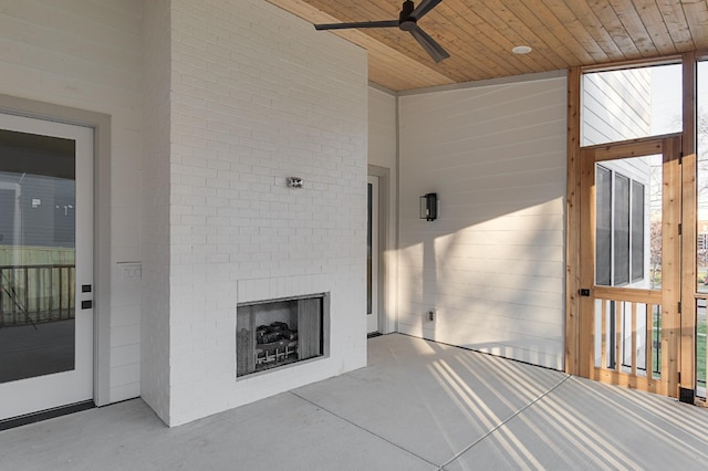 view of patio with a large fireplace and ceiling fan