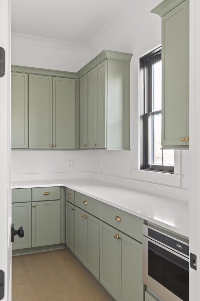 kitchen featuring green cabinetry, crown molding, and plenty of natural light