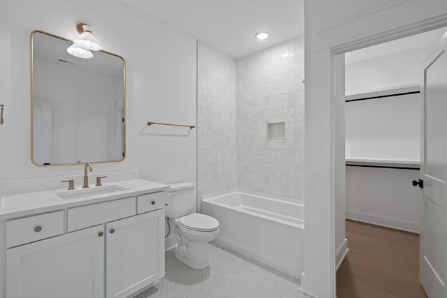 full bathroom with toilet, wood-type flooring, vanity, and tiled shower / bath combo