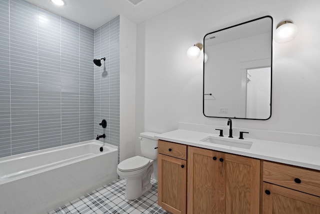 full bathroom featuring tile patterned flooring, toilet, vanity, and tiled shower / bath