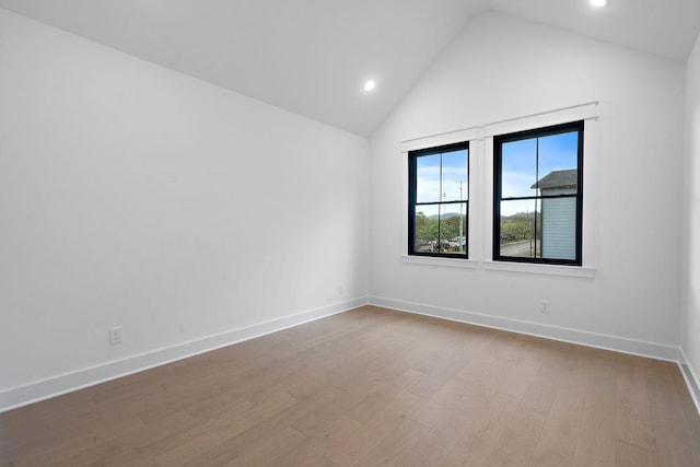 empty room featuring vaulted ceiling and light hardwood / wood-style flooring