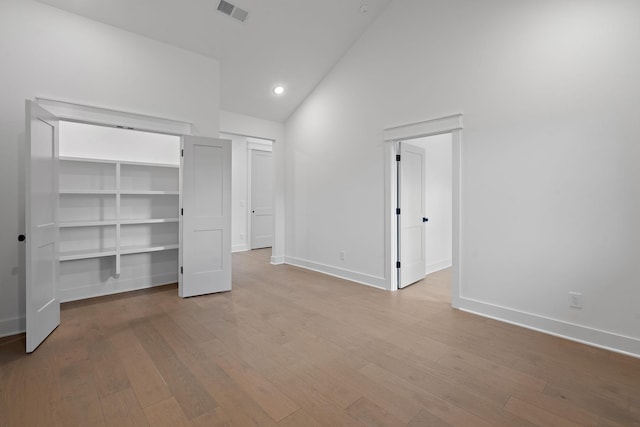 unfurnished bedroom with vaulted ceiling and light hardwood / wood-style flooring