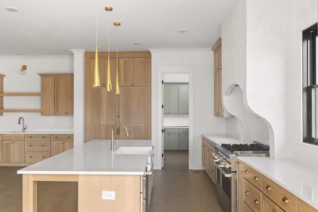 kitchen with sink, a center island with sink, double oven range, and hanging light fixtures