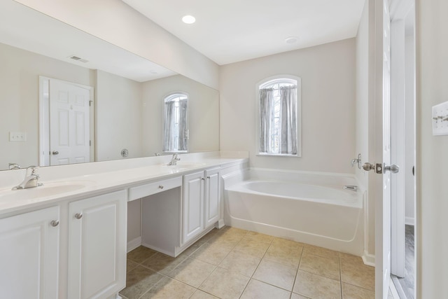 bathroom featuring a bathing tub, tile patterned flooring, and vanity