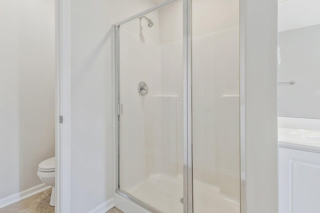 bathroom with toilet, tile patterned flooring, an enclosed shower, and vanity