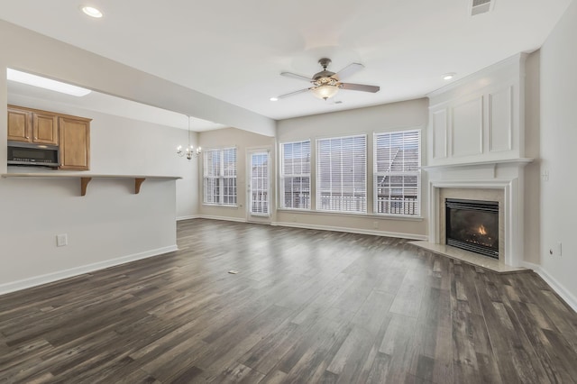 unfurnished living room with dark wood-type flooring and ceiling fan with notable chandelier