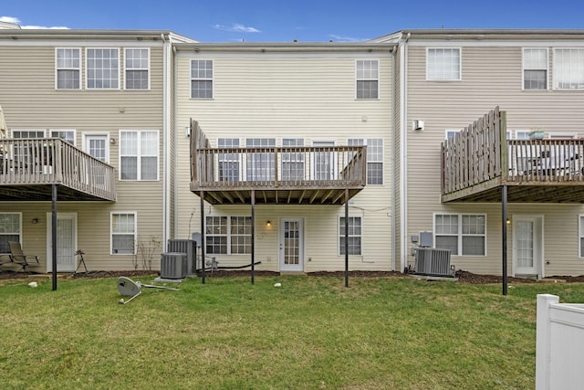 rear view of house with a yard and central AC unit