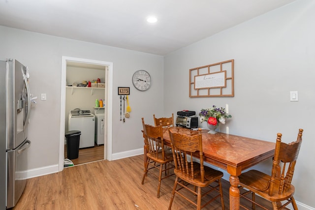 dining space with washing machine and clothes dryer and light hardwood / wood-style floors