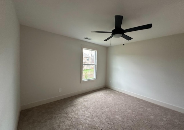 spare room featuring ceiling fan and carpet