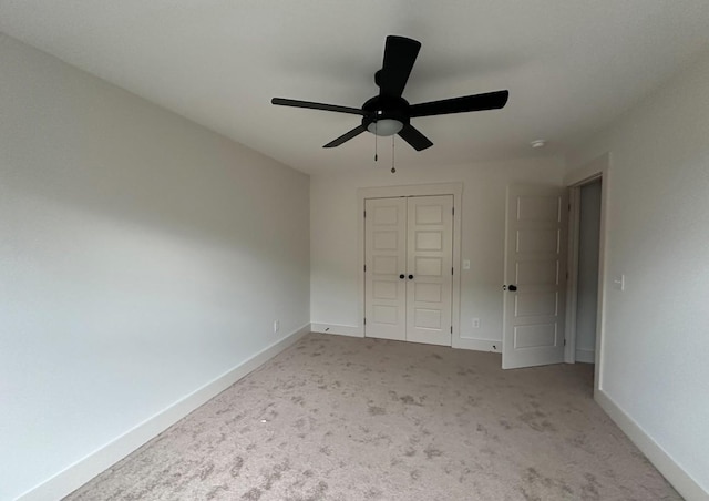 unfurnished bedroom with light carpet, ceiling fan, and a closet