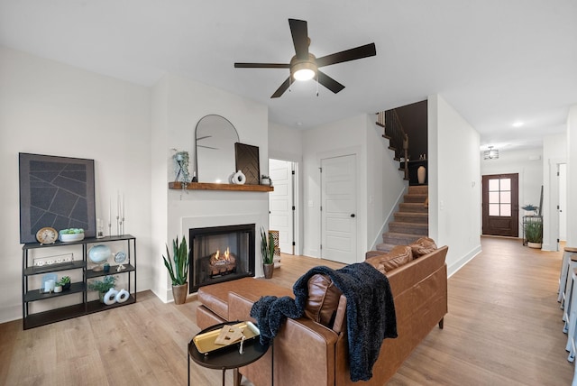 living room with light hardwood / wood-style flooring and ceiling fan