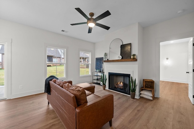 living room featuring ceiling fan and light hardwood / wood-style floors