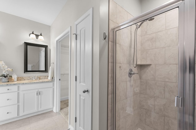 bathroom with tile patterned flooring, a shower with door, and vanity