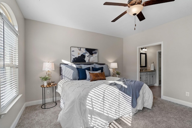 carpeted bedroom with ceiling fan, multiple windows, and ensuite bathroom