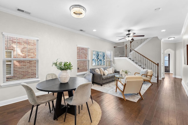 dining room featuring dark wood-type flooring, a wealth of natural light, and crown molding