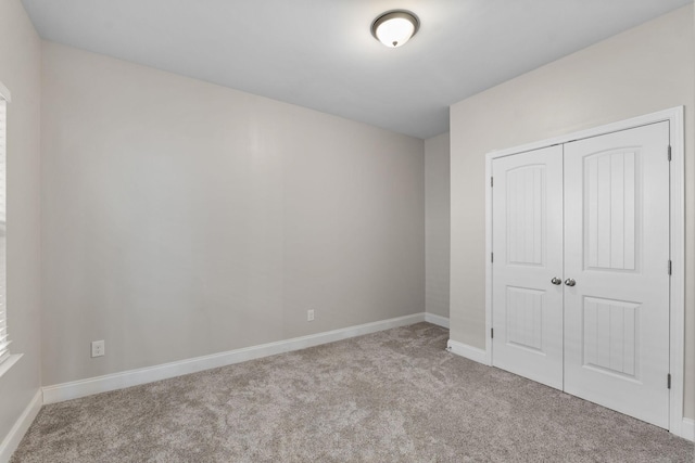 unfurnished bedroom with light carpet and a closet