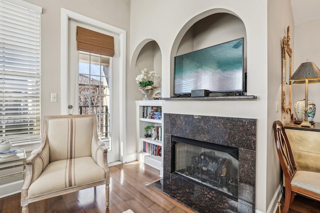 sitting room with a fireplace and hardwood / wood-style flooring