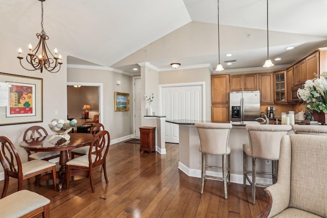 kitchen with appliances with stainless steel finishes, vaulted ceiling, and pendant lighting