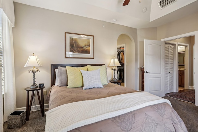 carpeted bedroom with ceiling fan, a spacious closet, and a closet