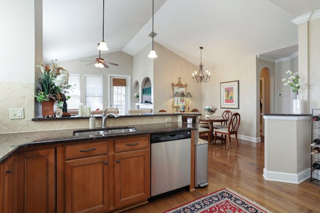 kitchen featuring stainless steel dishwasher, pendant lighting, tasteful backsplash, ceiling fan with notable chandelier, and sink