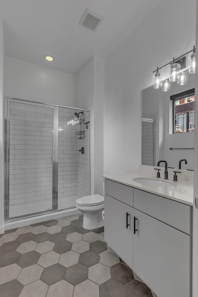 bathroom featuring toilet, vanity, tile patterned flooring, and walk in shower