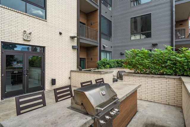 view of patio / terrace featuring an outdoor kitchen, french doors, and a grill