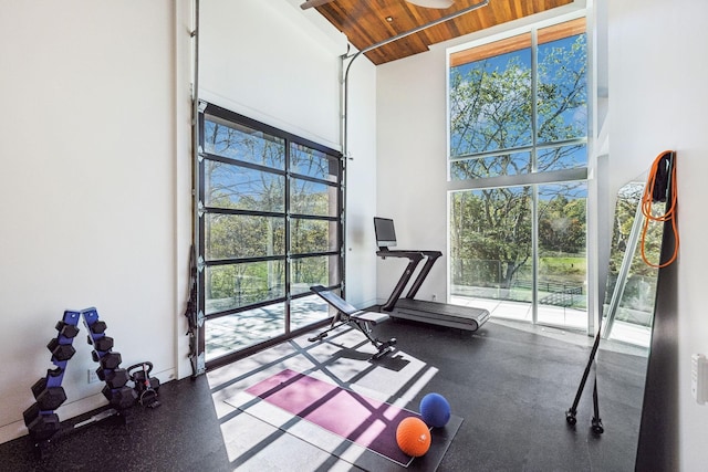 workout room with wood ceiling and a towering ceiling