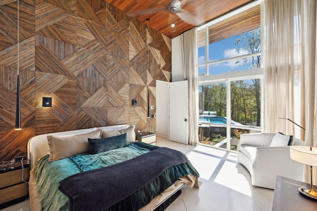 bedroom with a high ceiling, ceiling fan, and light tile patterned floors