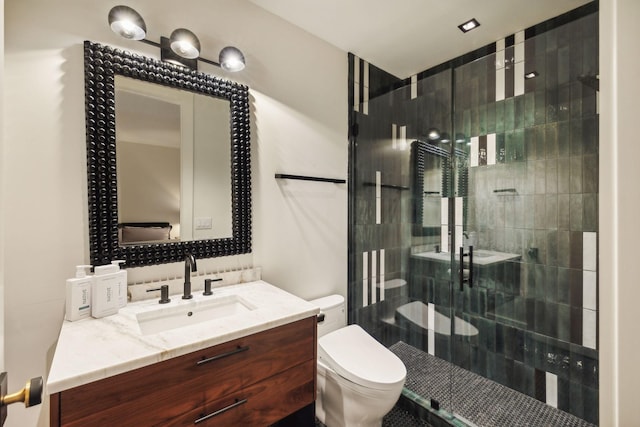 bathroom featuring toilet, an enclosed shower, and vanity