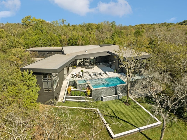 rear view of property with a yard and a patio