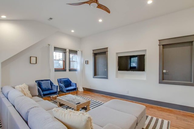 living room featuring lofted ceiling, light wood-type flooring, and ceiling fan