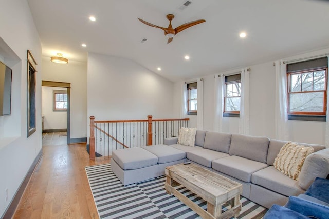 living room featuring light hardwood / wood-style floors, ceiling fan, and vaulted ceiling