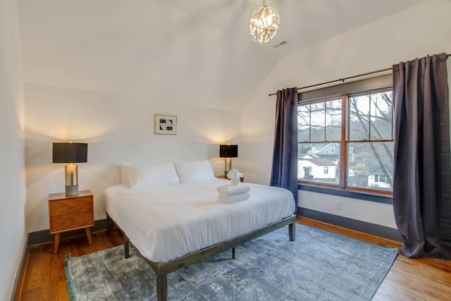 bedroom featuring lofted ceiling and wood-type flooring