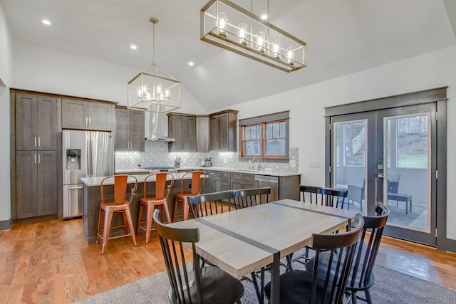 dining room with light hardwood / wood-style floors, french doors, plenty of natural light, and sink