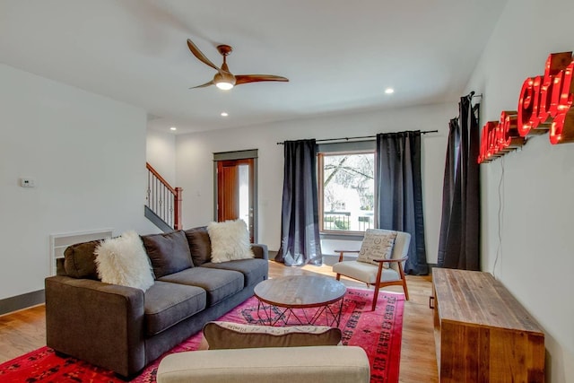 living room featuring light wood-type flooring and ceiling fan