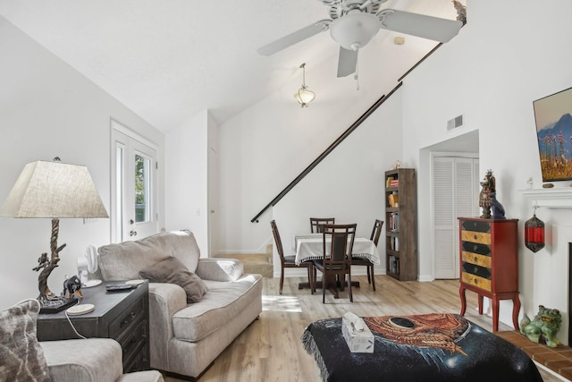 living room featuring light hardwood / wood-style floors, ceiling fan, and vaulted ceiling