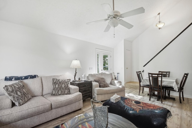 living room featuring hardwood / wood-style flooring, ceiling fan, and vaulted ceiling