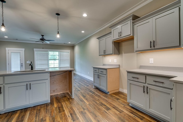 kitchen featuring hanging light fixtures, gray cabinets, crown molding, ceiling fan, and sink