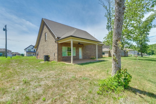 view of home's exterior with a patio area, ceiling fan, central AC unit, and a yard