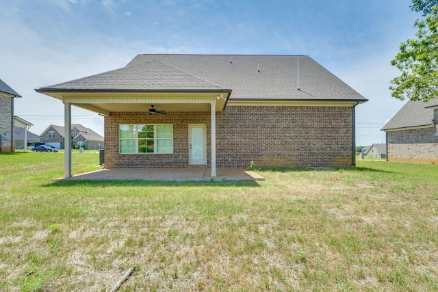 rear view of property with ceiling fan, a yard, and a patio