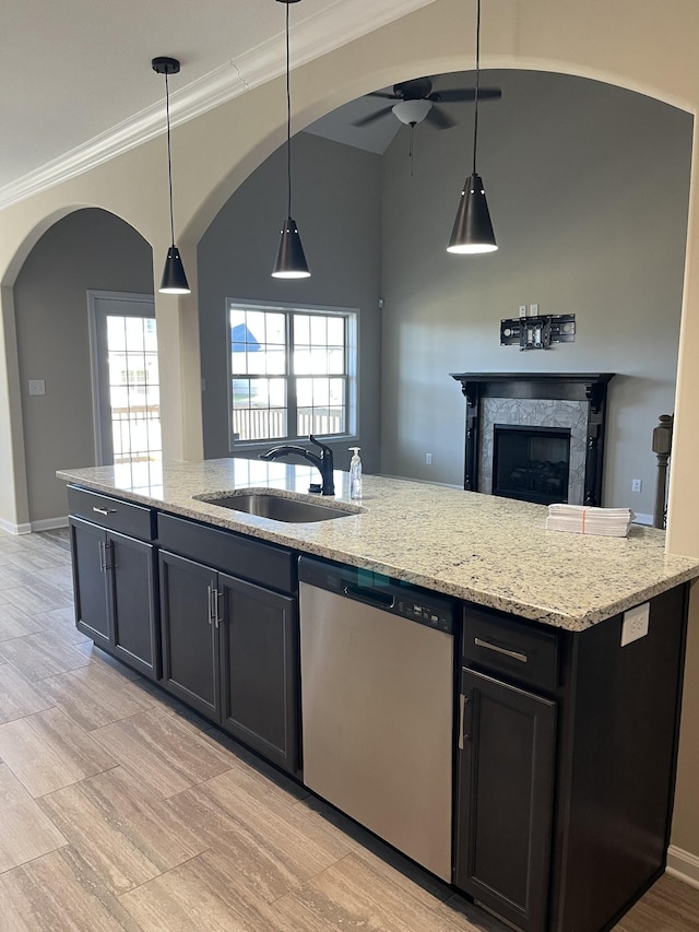 kitchen featuring dishwasher, light stone countertops, ceiling fan, pendant lighting, and sink