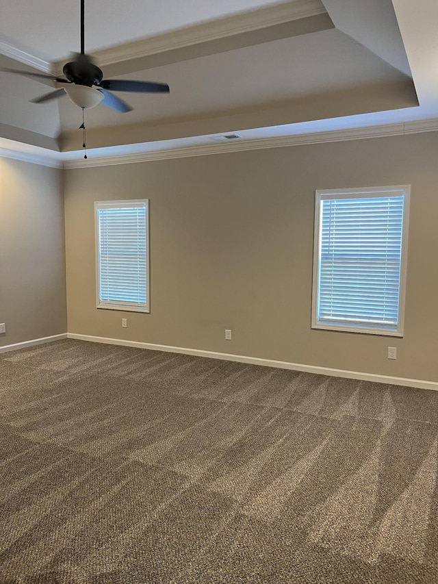 spare room with a raised ceiling, ceiling fan, carpet, and crown molding