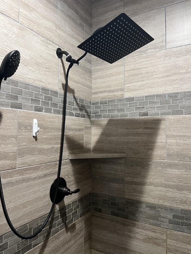 interior details featuring a tile shower